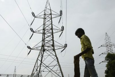A man stands in front of an electric pylon installed at a power house in Allahabad